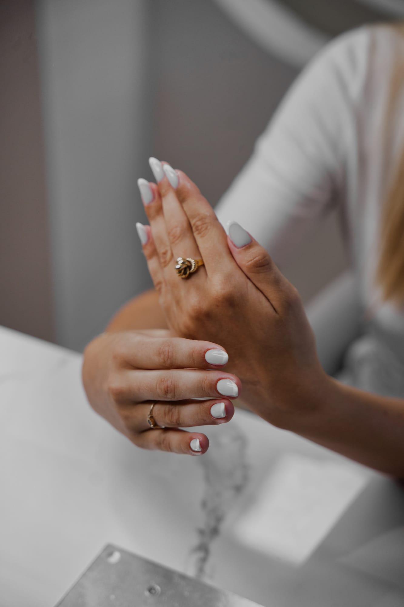 Ongles lilas laiteux, mains posées sur le marbre